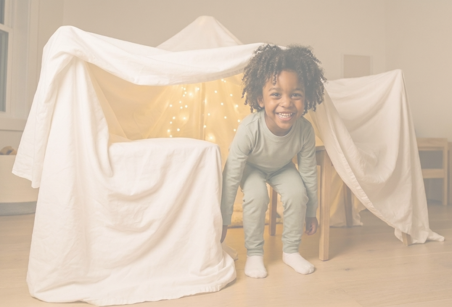 Child playing inside a makeshift tent made of white fabric in a room with wooden floor and furniture.